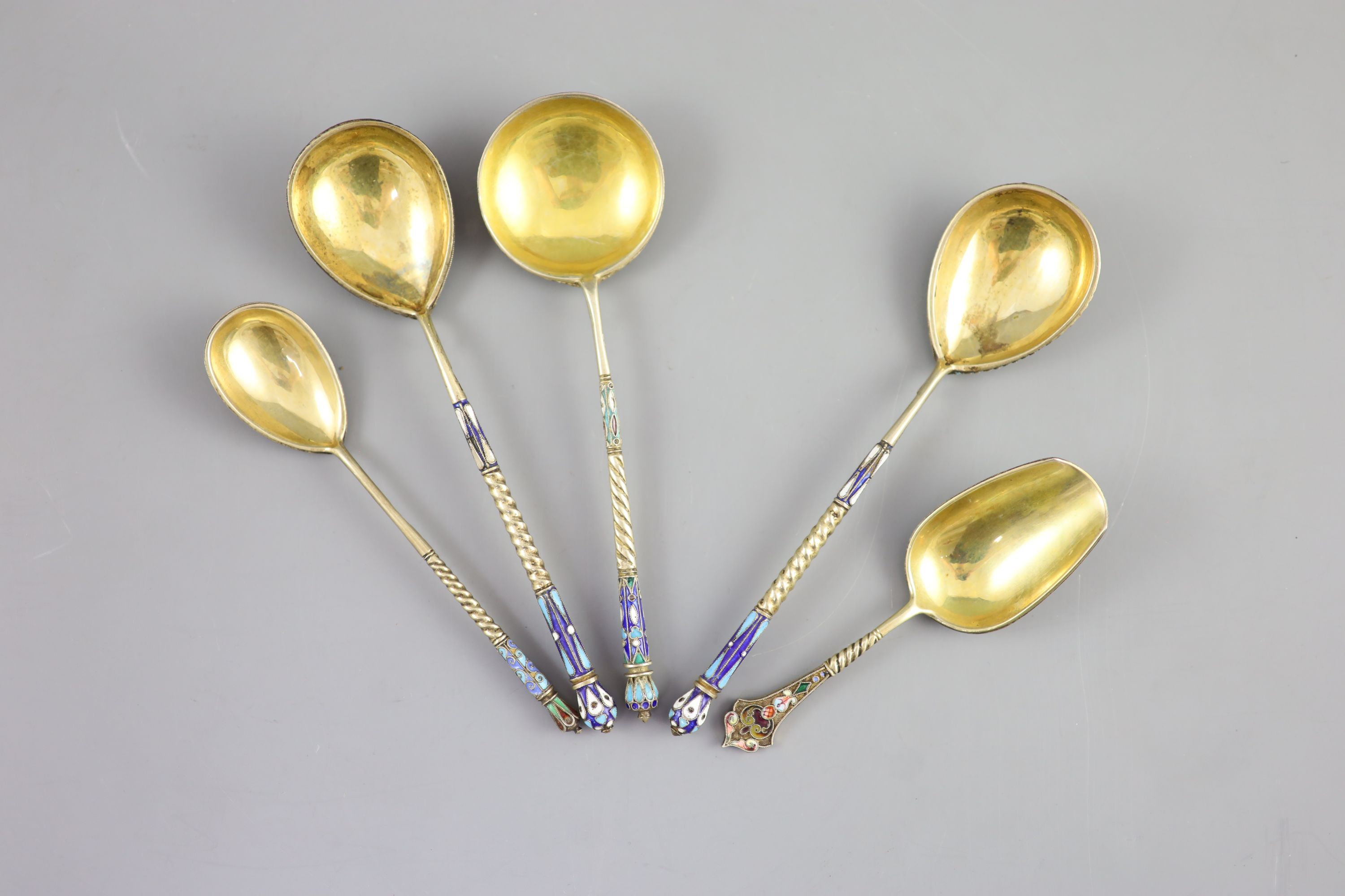 Five assorted late 19th/early 20th century Russian 84 zolotnik silver gilt and cloisonne enamel spoons and a similar napkin ring